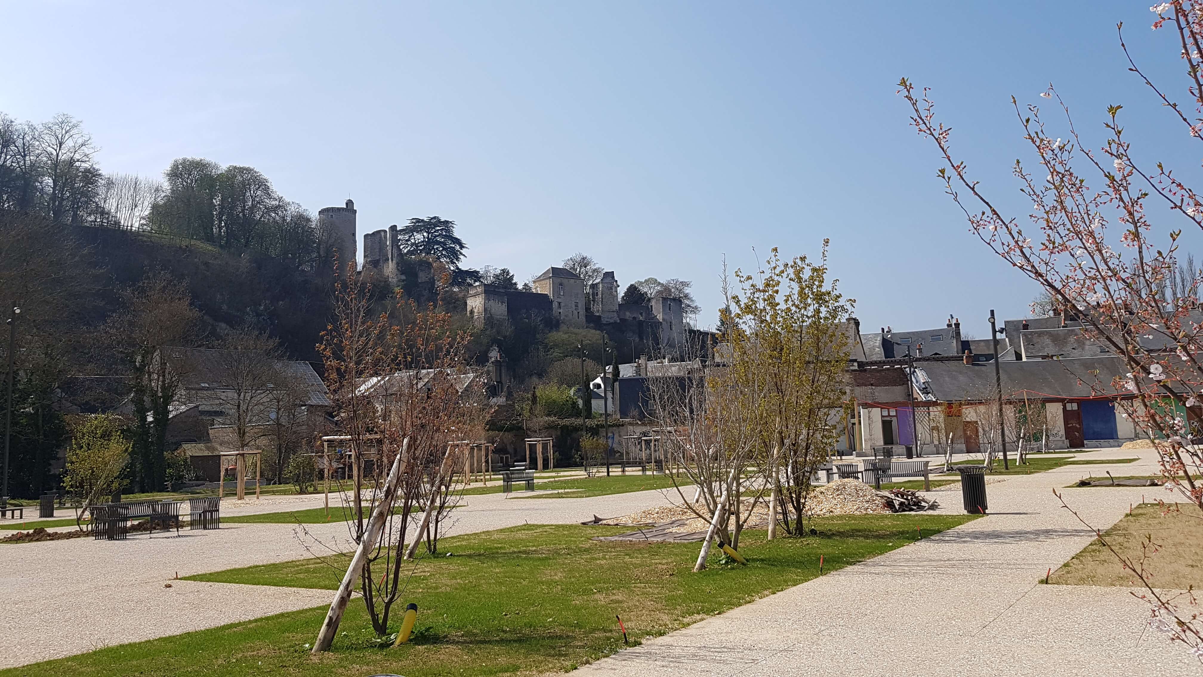 Parking Rochambeau réaménagé avec des carrés de pelouse, des arbustes. Au loin le château se dessine sur la butte.